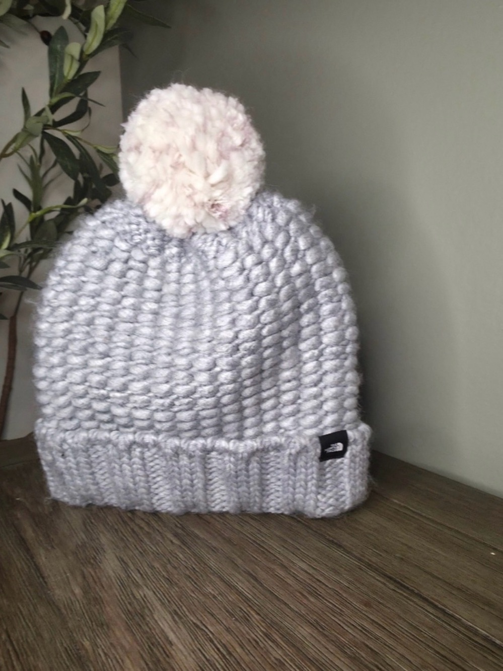 The North Face Light Gray Knit
Beanie with Cream Pom